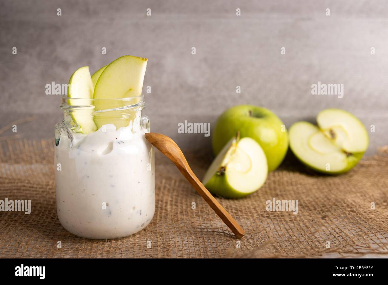 Frühstück Bio-Joghurt in einem Mixbecher mit reiner Schokolade und frischen Apfelscheiben Stockfoto