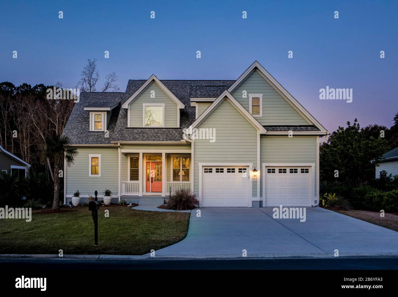 Vordere Erhöhung des schönen Hauses leuchtet in der Dämmerung auf. Stockfoto