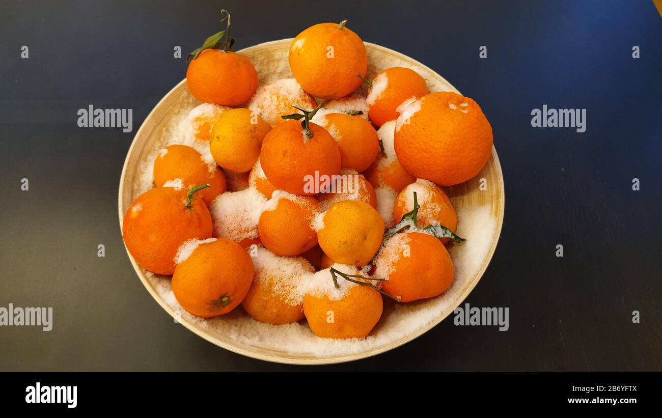 Verschneite Orangen in einer Holzschale Stockfoto