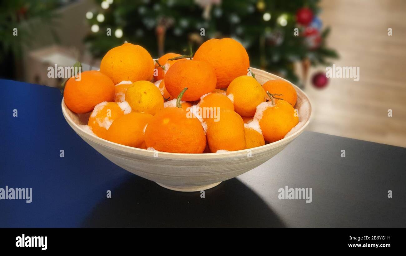 Verschneite Orangen in einer Holzschale Stockfoto