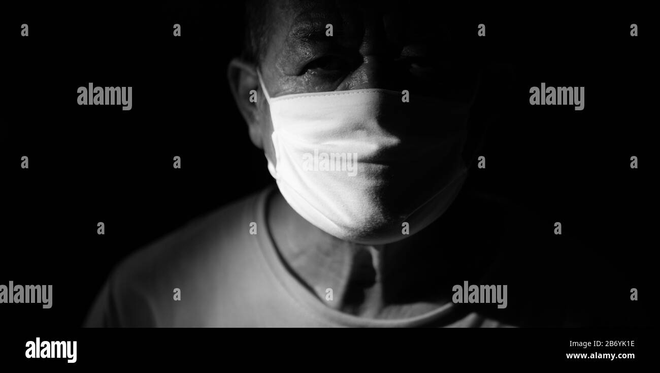 Porträt eines Mannes, der vor Covid-19 Angst hatte. Erschrockter Mann steht in einer schützenden medizinischen Maske gegen Viren und Infektionen, medizinisches maskiertes isoliertes Studio. Coron Stockfoto