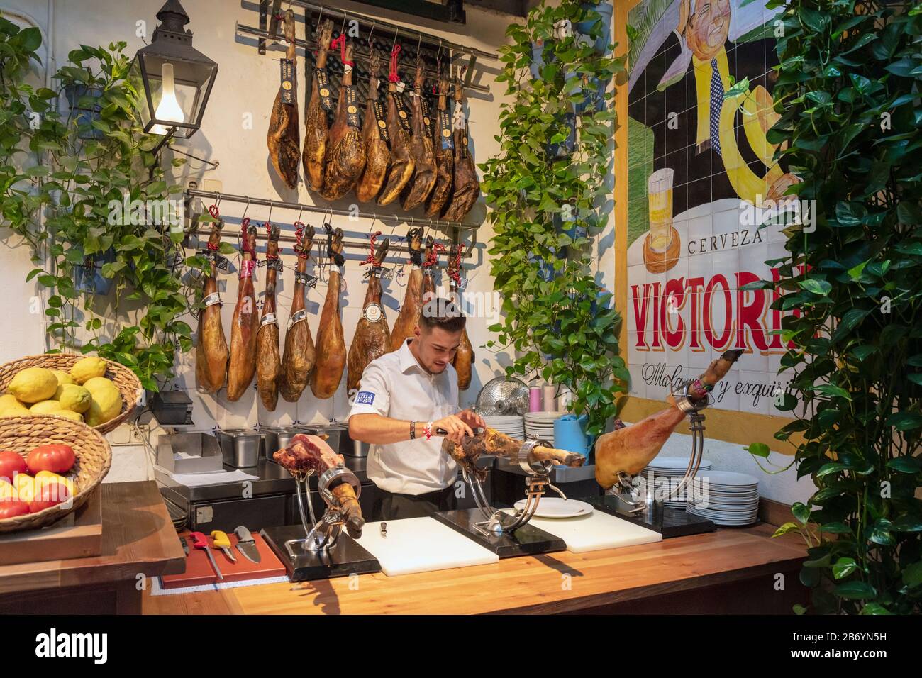 Innenbereich Bodego-Bar El Pimpi. Ein Kortador oder Schinkenschneider, der ein Bein aus Schinken zerschnitt. Málaga, Costa del Sol, Provinz Málaga, Andalusien, Südspanien. Stockfoto