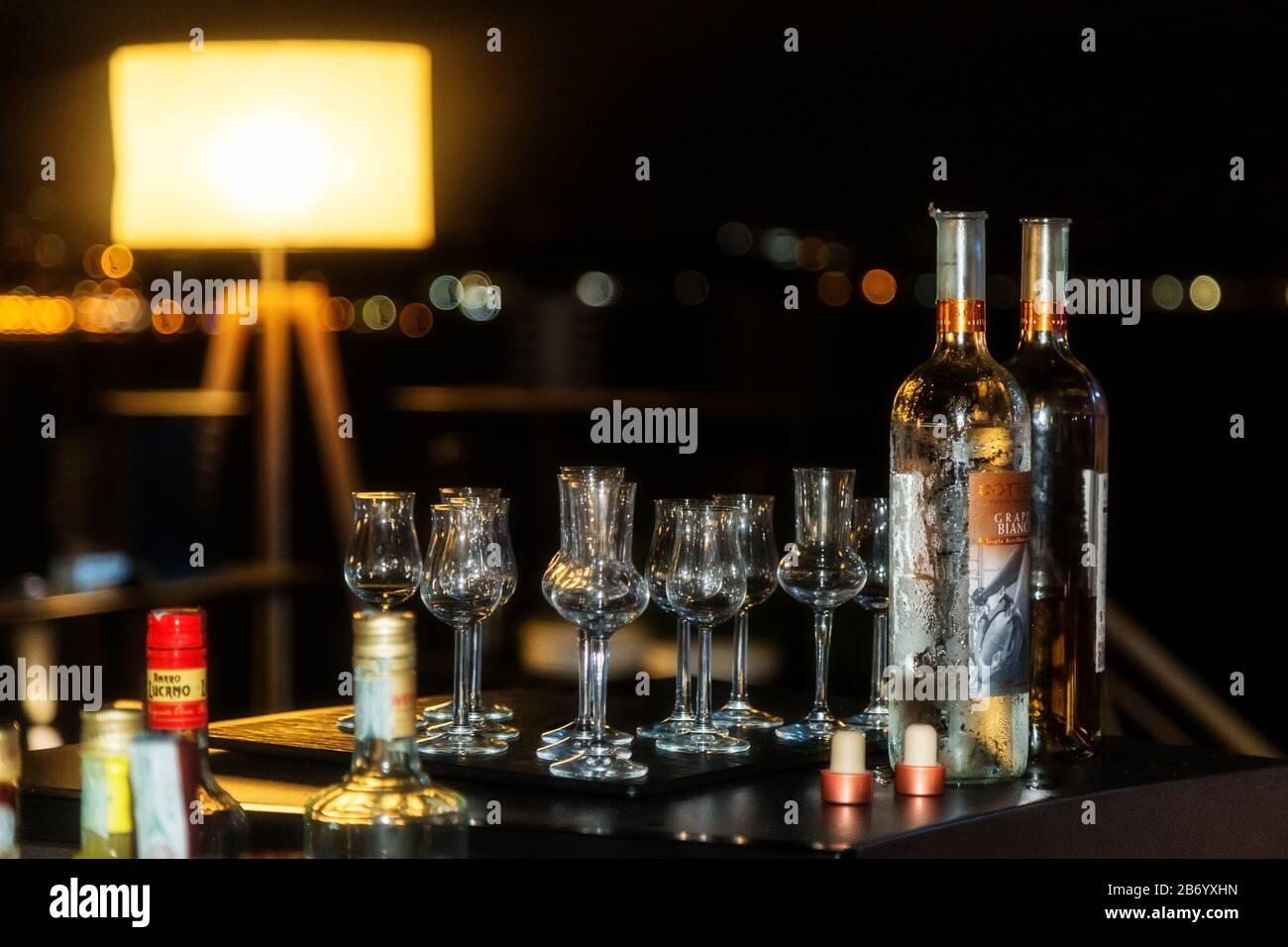 Nachtszenen mit verschiedenen Flaschen und Brillen aus Alkohol und Spirituosen an einer Bar. Große Auswahl an importierten und inländischen Etiketten. Stockfoto