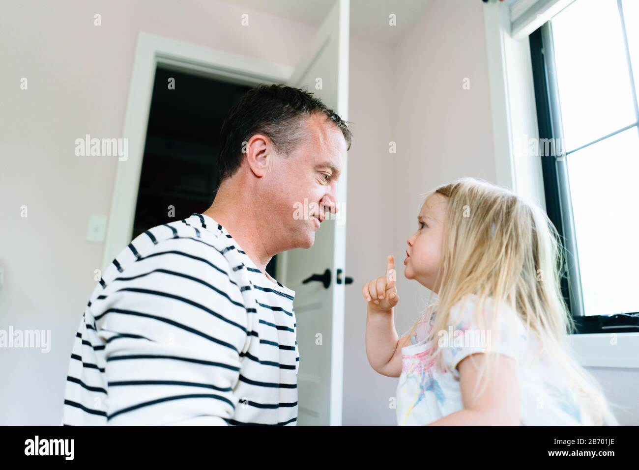 Seitenansicht eines Kleinkindes, das für ihren Vater winkte, ruhig zu sein Stockfoto