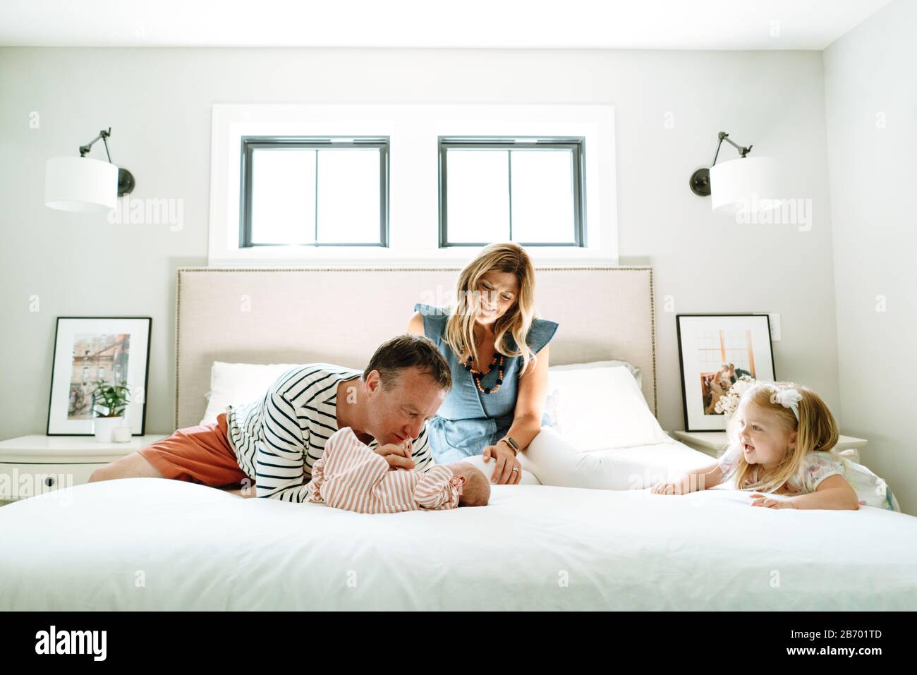Eine neue vierköpfige Familie spielt zusammen in einem modernen Schlafzimmer Stockfoto