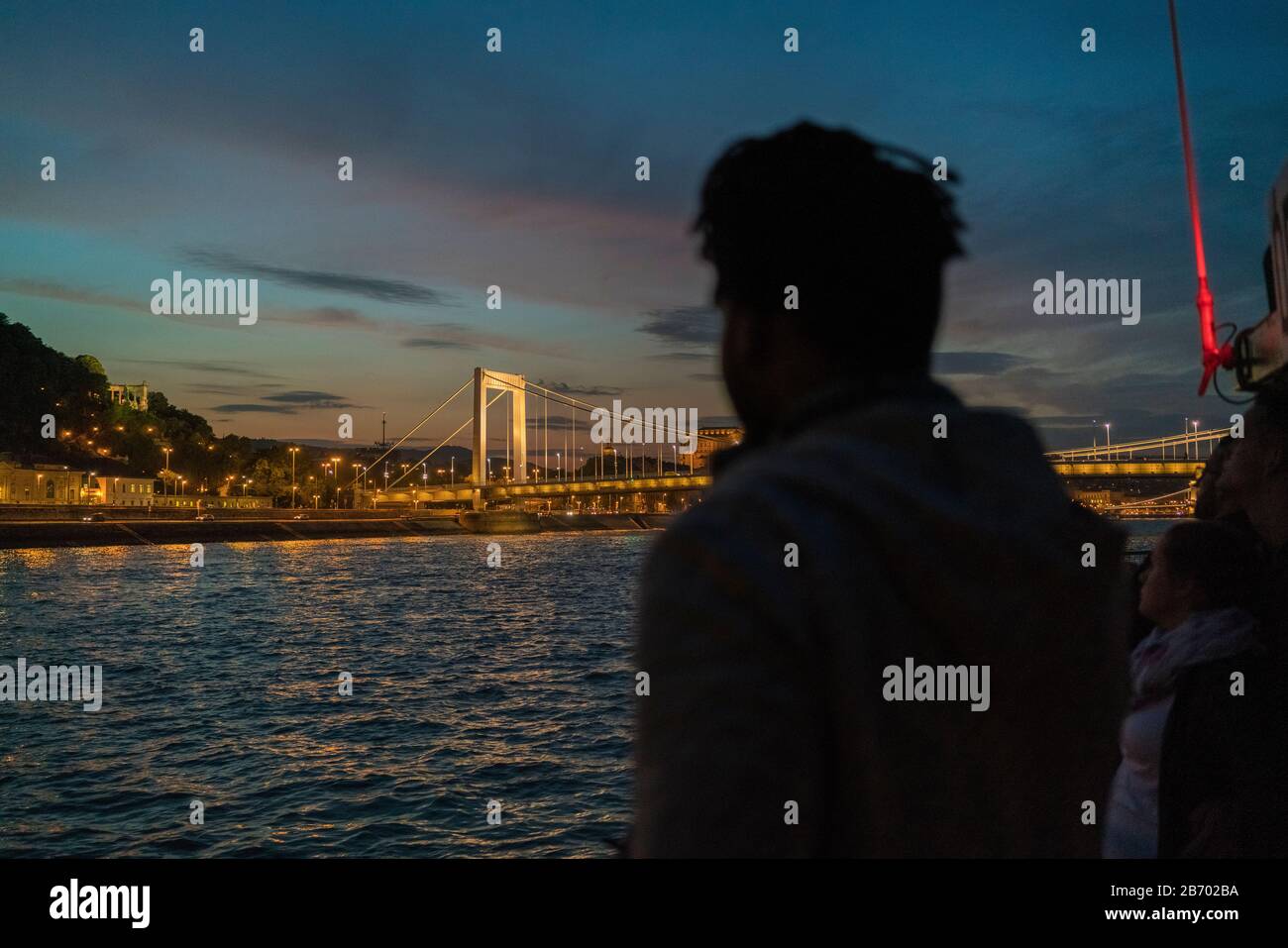 Afrikanischer Mann, der nachts die beleuchtete Elisabeth-Brücke abbildlicht Stockfoto