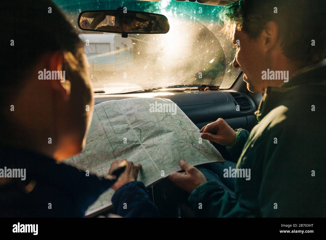Ein junges Paar schaut sich die Karte auf einer Autoreise an. Stockfoto