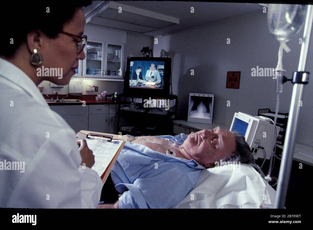 McGehee, Arkansas USA 1996: Schwarze Ärztin untersucht Patienten mit Checkschmerzen und möglichen Herzinfarkten in einem ländlichen Krankenhaus in Arkansas. Modell Freigegeben. ©Bob Daemmrich Stockfoto