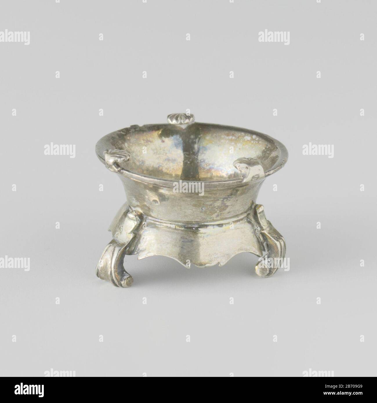 Kompoor Rond kompoor op drie naar binnen gebogen, Platte, voluutvormige poten. De brede onderrand ist geschulpt. Aan de bovenrand zijn drie schelpvormige staanders bevestigd. Het komfoor is gemerkt: Gekroonde O, een bijltje en een onleesbaar merk. Hersteller : zilversmid: AnoniemPlaats Herstellung: Nederland dating: CA. 1730 - ca. 1.680 Physische Kenmerken: Zilver Material: Zilver Abmessungen: H 2.6 cm. × d 3,8 cm. × g 29 gr Stockfoto