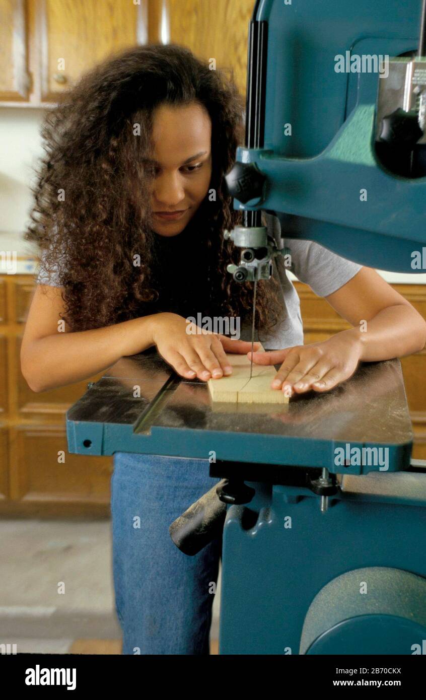 Austin, Texas USA, 1998: Die lockeren Haare einer afroamerikanischen Frau sind unsicher, da sie Bandsäge verwendet. HERR ©Bob Daemmrich Stockfoto