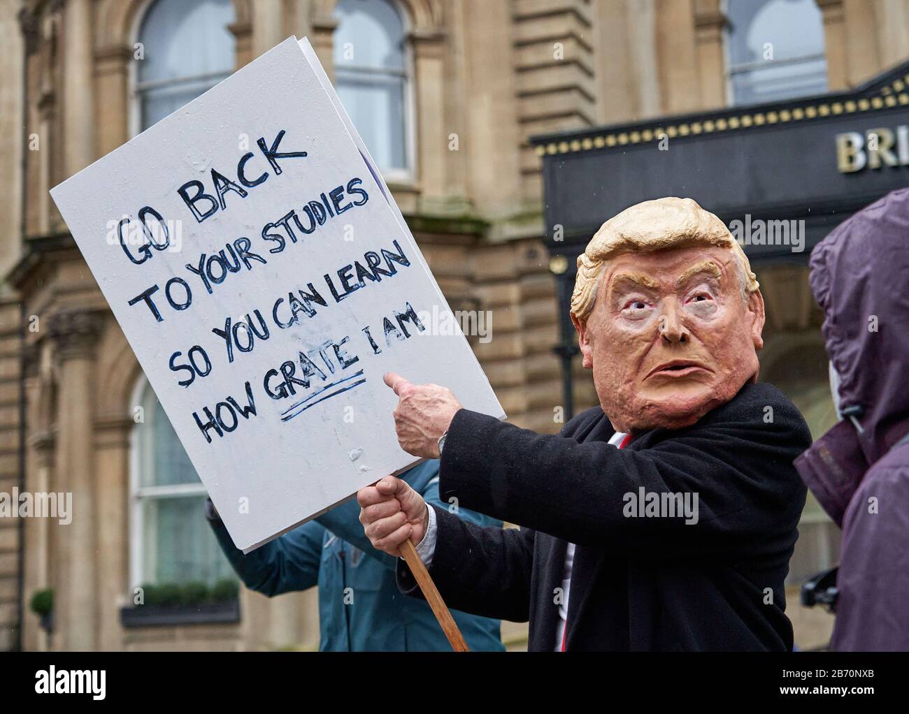 Mann in einer Donald Trump-Maske, die Kinder für den Schulstreik auf dem Greta Thunberg Marsch zum Klima in Bristol UK anmahnen lässt Stockfoto