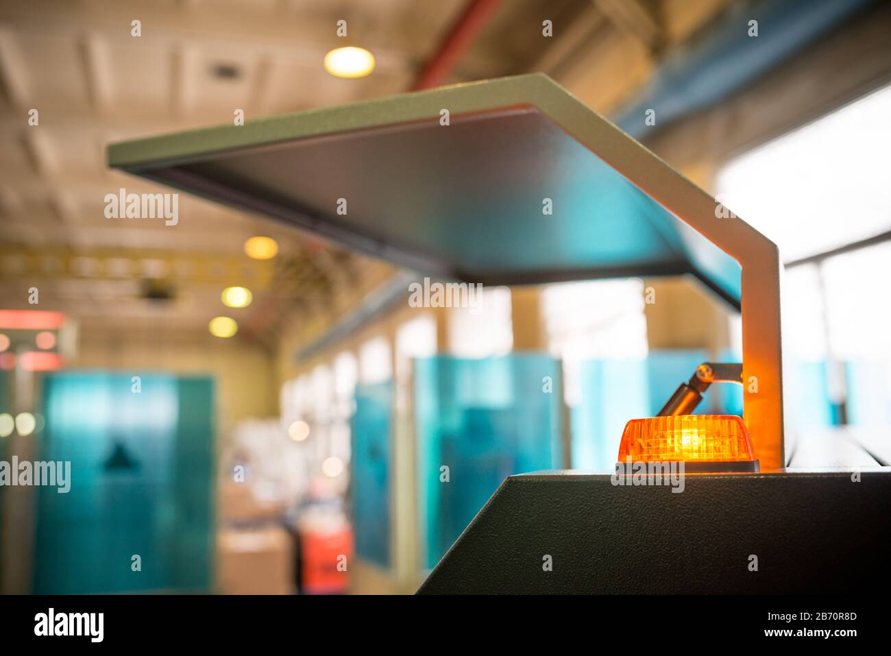 Offene Wand des Metallgehäuses mit pneumatischen Schließern und orangefarbener Warnleuchte im Kunststoffgehäuse Stockfoto