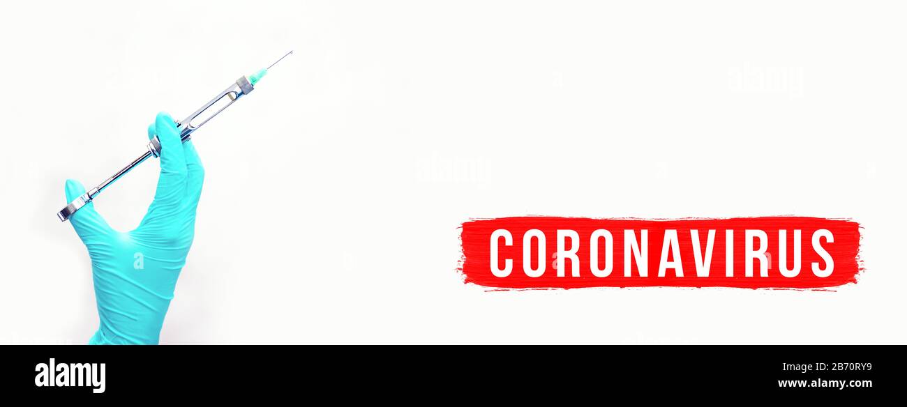 Hand in Handschuh mit medizinischer Spritze. Ein Konzept zum Thema Coronavirus. Auf dem hellen Hintergrund. Banner Stockfoto