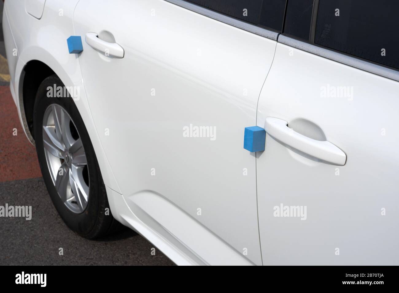 Nahansicht der Tür und Des Schaumstoffschutzes von White Car. Blaue weiche Blöcke Stecken Am Rand Fest, um Schäden an anderen Fahrzeugen in Korea zu vermeiden. Stockfoto