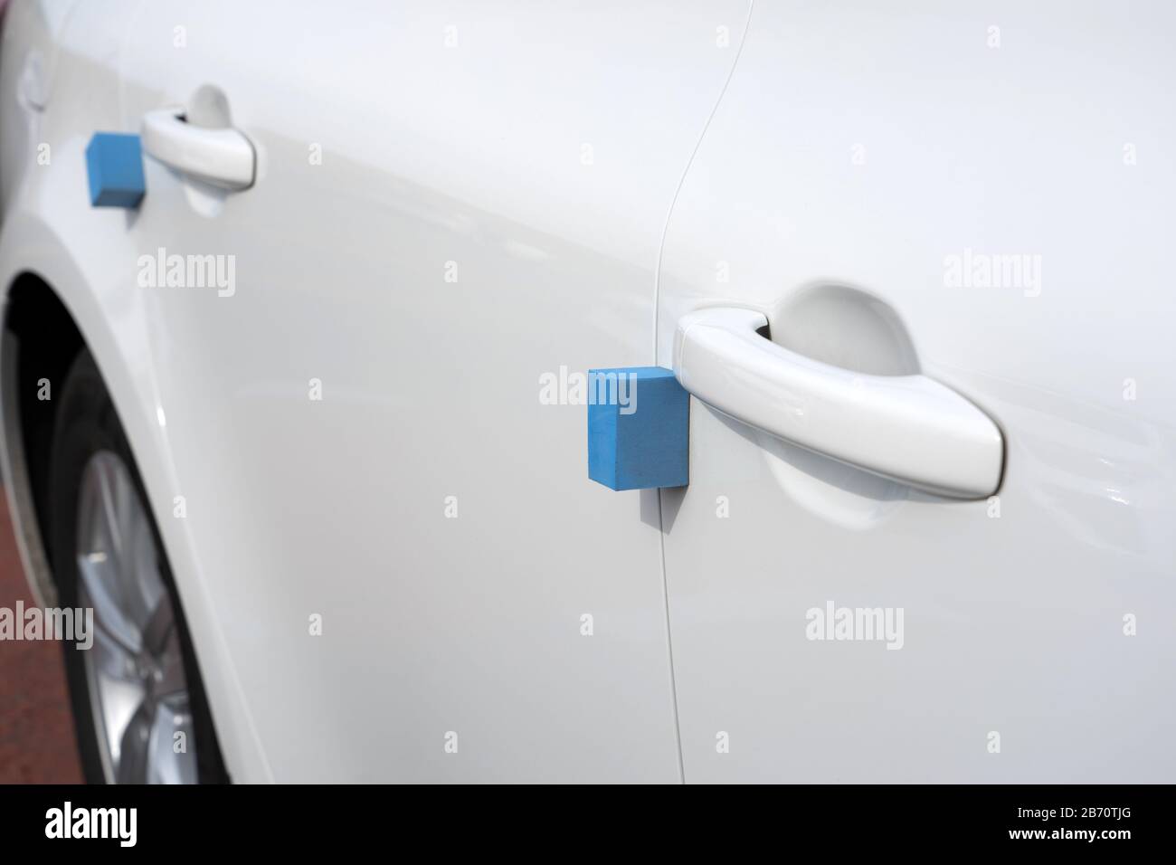 Nahansicht der Tür und Des Schaumstoffschutzes von White Car. Blaue weiche Blöcke Stecken Am Rand Fest, um Schäden an anderen Fahrzeugen in Korea zu vermeiden. Stockfoto