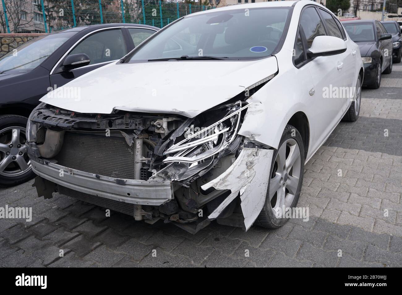 Ein geparktes Fahrzeug stürzte auf der Straße mit gebrochenen Scheinwerfern und Vorderansicht ab Stockfoto