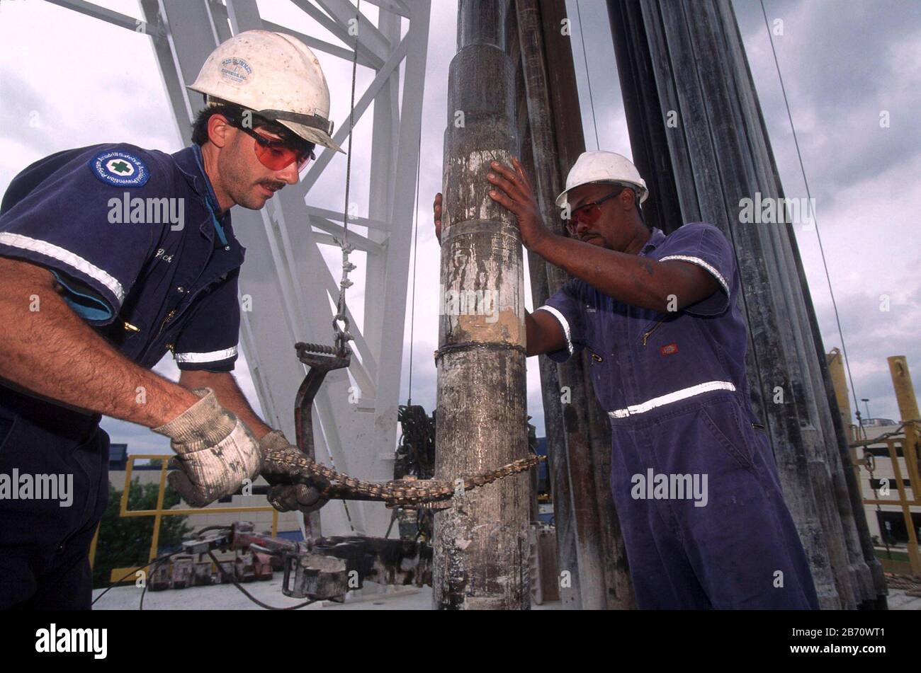 Houston, Texas, USA: Raue, harthüte tragende Bohrer, die auf einer Ölbohrplattform einen Bohrer installieren. ©Bob Daemmrich Stockfoto