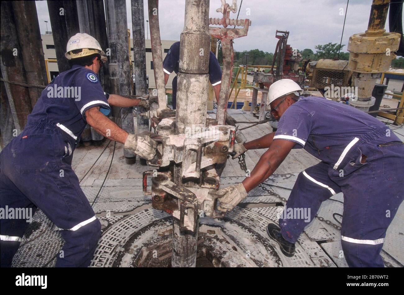 Houston, Texas, USA: Raue, harthüte tragende Bohrer, die auf einer Ölbohrplattform einen Bohrer installieren. ©Bob Daemmrich Stockfoto