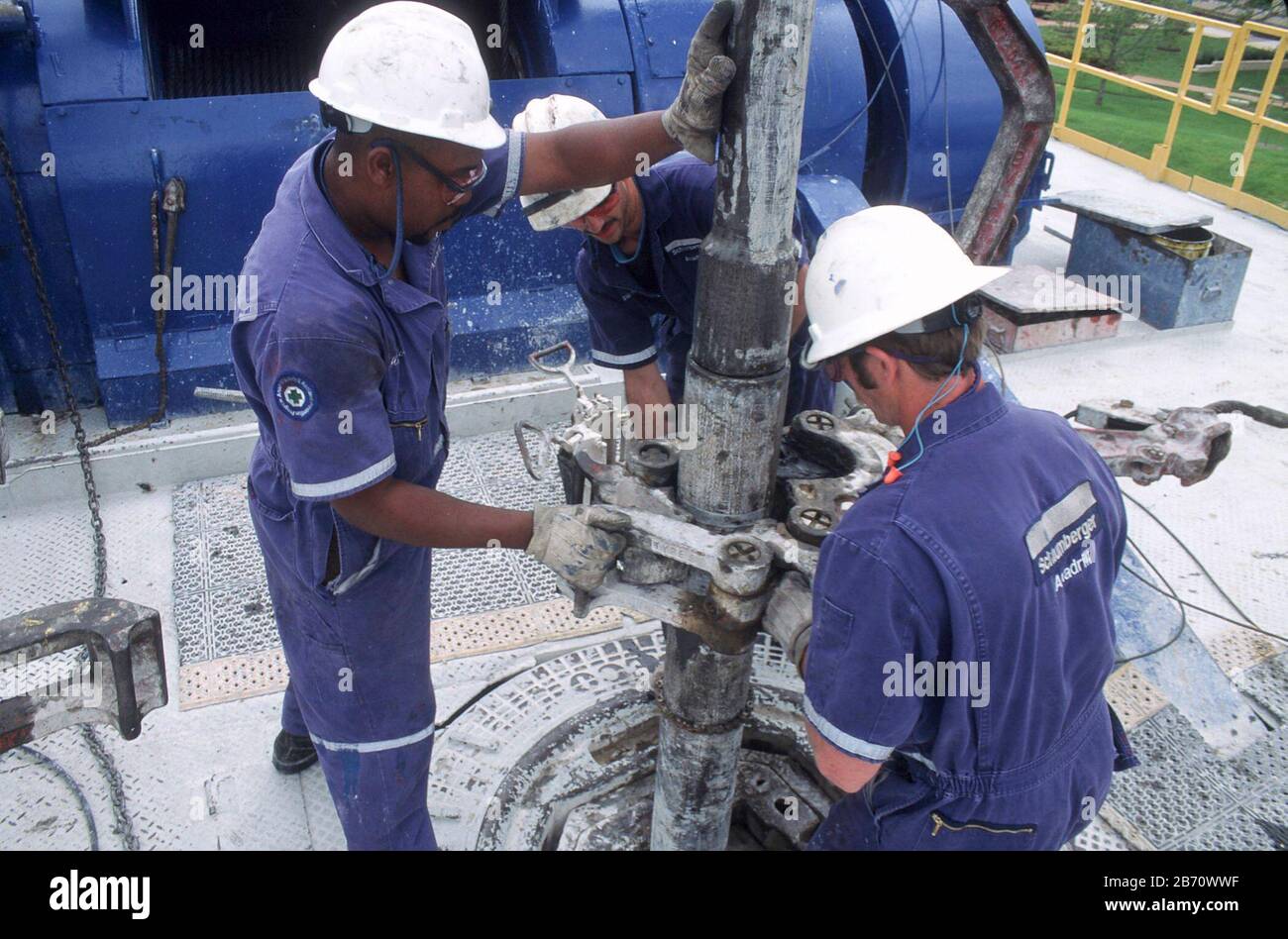 Houston, Texas, USA: Raue, harthüte tragende Bohrer, die auf einer Ölbohrplattform einen Bohrer installieren. ©Bob Daemmrich Stockfoto