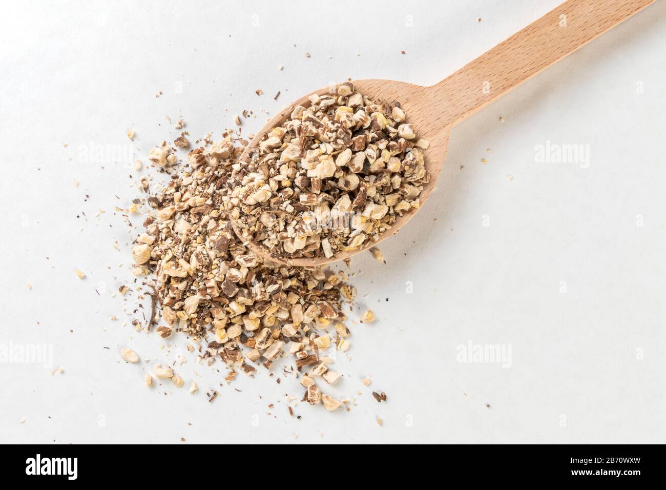 Löwenzahnwurzel oder in lateinischer Taraxaci-Radix in Holzlöffel isoliert auf weißem Grund Heilkräuter. Kräutermedizin. Alternative Medizin Stockfoto