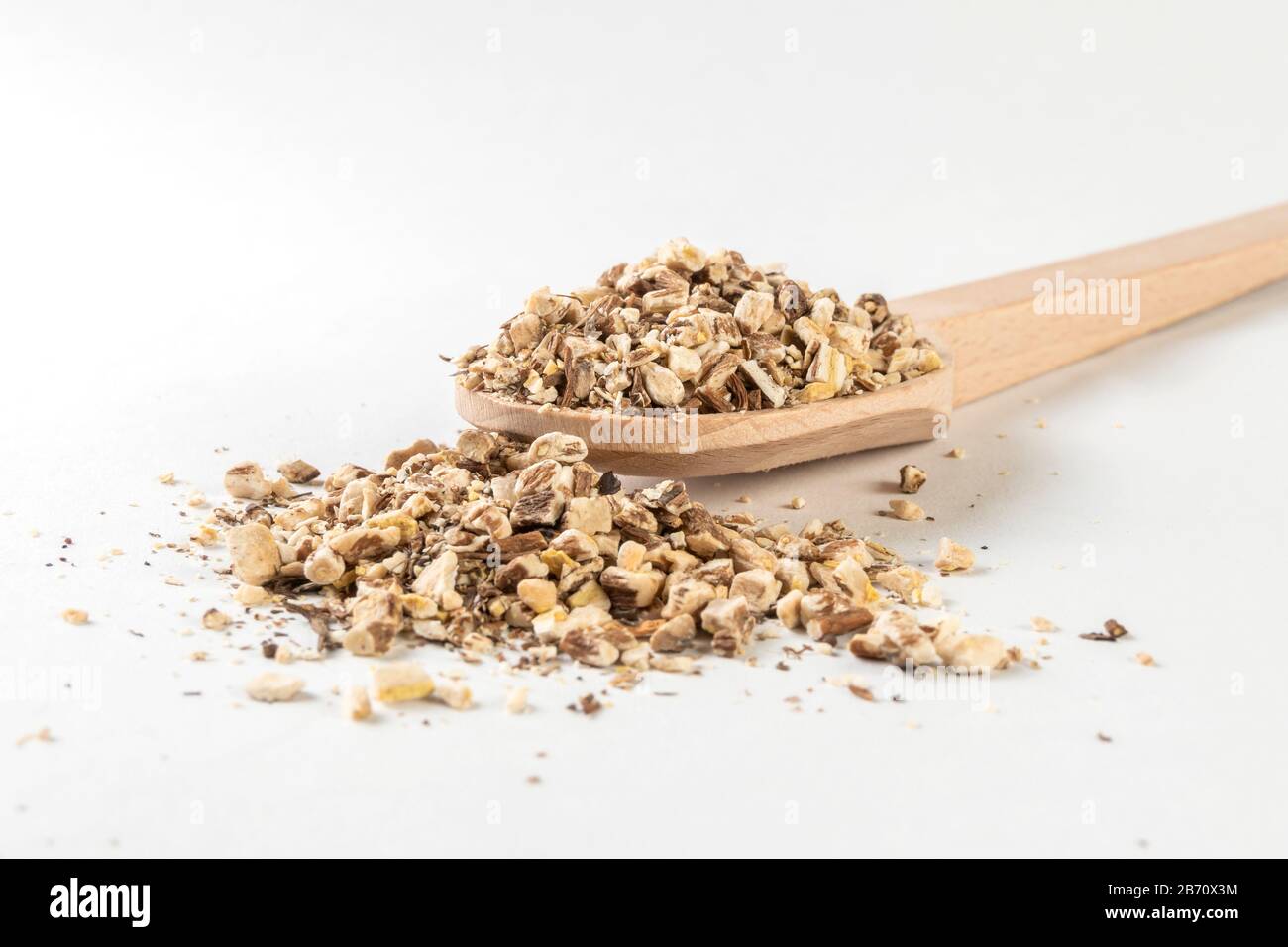 Löwenzahnwurzel oder in lateinischer Taraxaci-Radix in Holzlöffel isoliert auf weißem Grund Heilkräuter. Kräutermedizin. Alternative Medizin Stockfoto