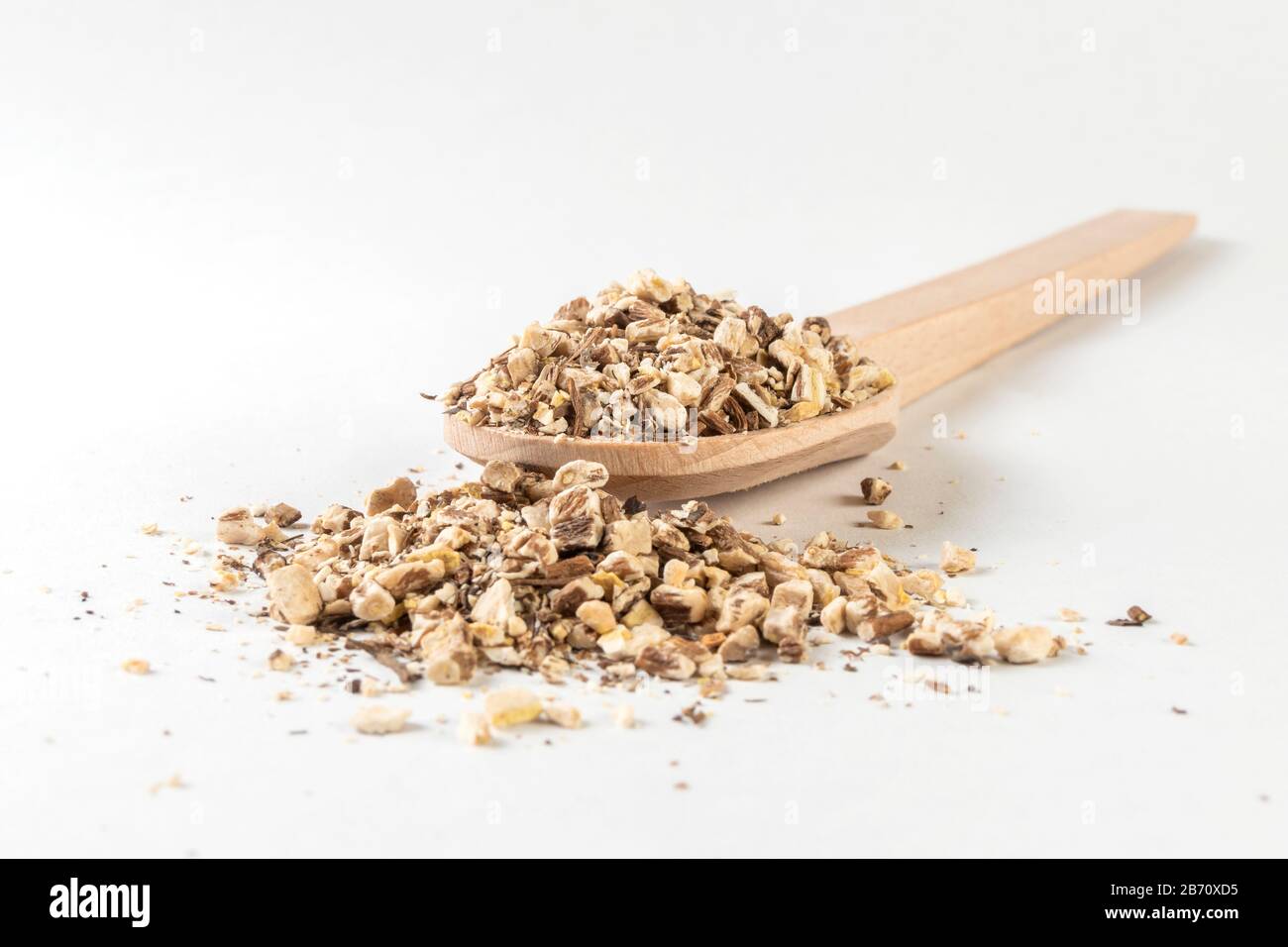 Löwenzahnwurzel oder in lateinischer Taraxaci-Radix in Holzlöffel isoliert auf weißem Grund Heilkräuter. Kräutermedizin. Alternative Medizin Stockfoto