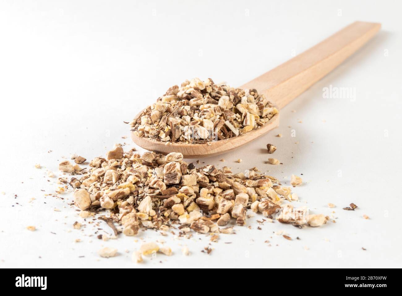 Löwenzahnwurzel oder in lateinischer Taraxaci-Radix in Holzlöffel isoliert auf weißem Grund Heilkräuter. Kräutermedizin. Alternative Medizin Stockfoto