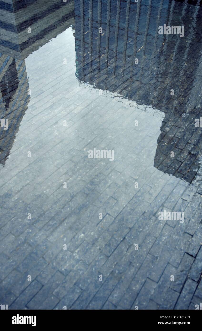 Bürogebäude spiegelten sich in einer großen Wasserpfütze wider Stockfoto