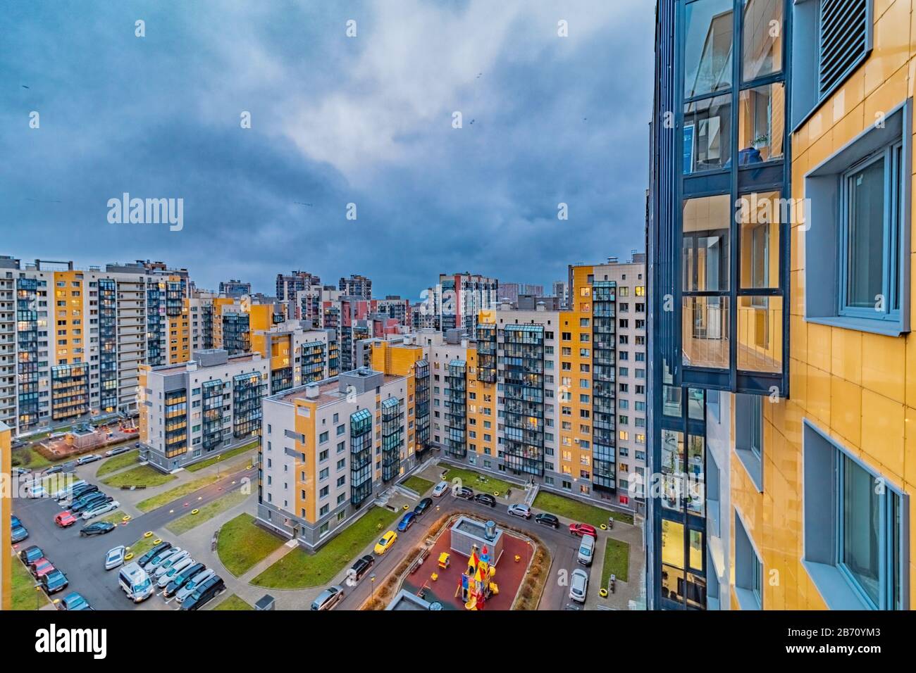 Neue moderne Wohnbauten mit hellen Fenstern im Vorstadtviertel am Abend Stockfoto