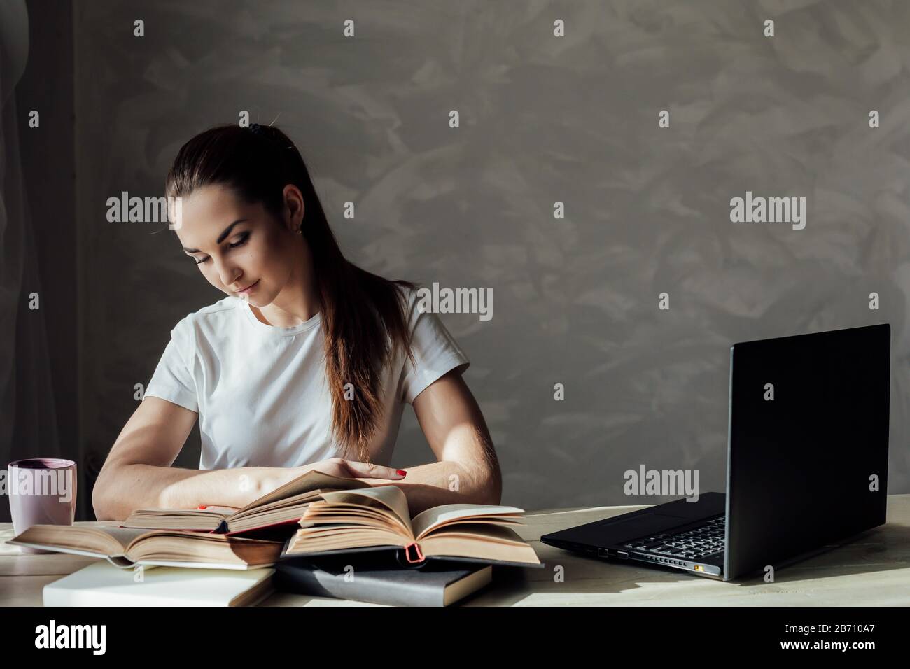 Mädchen bereitet sich auf die Prüfung vor und liest ein Buch Stockfoto