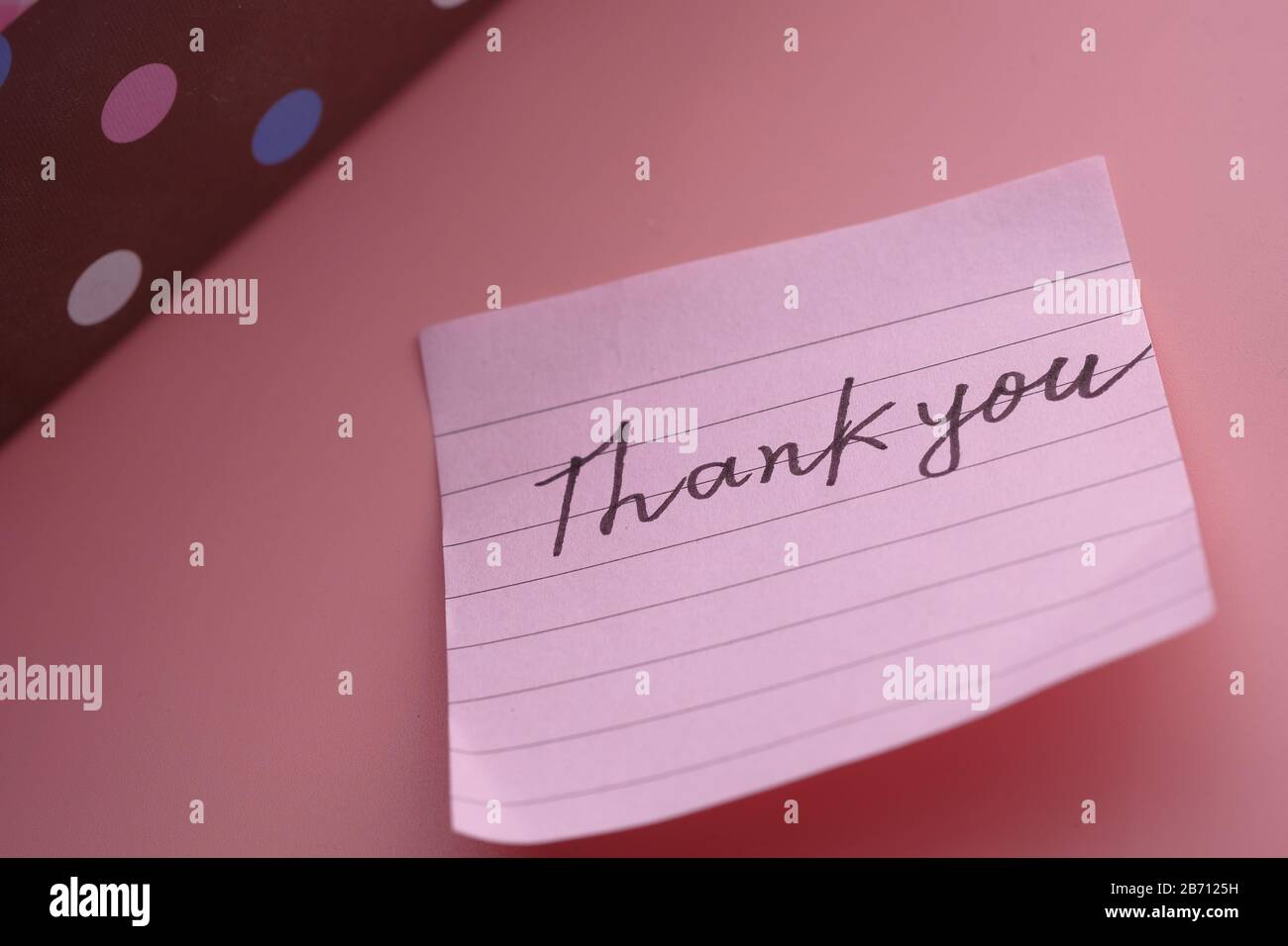 Dankesnachricht mit Geschenkbox auf pinkfarbenem Hintergrund Stockfoto