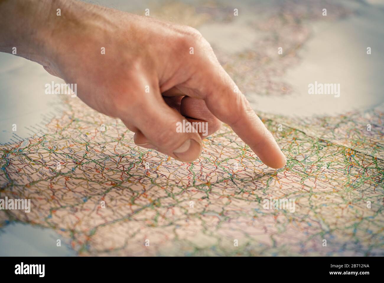 Der Zeigefinger zeigt auf eine Stelle auf der Karte. Reisekonzept. Stockfoto