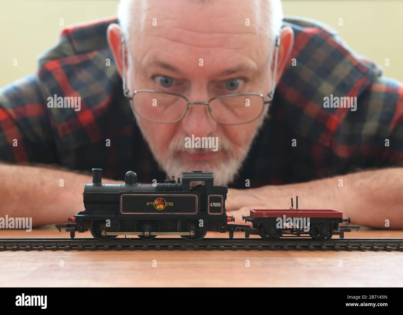 Ein älterer Mann beobachtet einen alten Spielzeug-Dampfzug von einem Tri-ang-Zug in Großbritannien Stockfoto