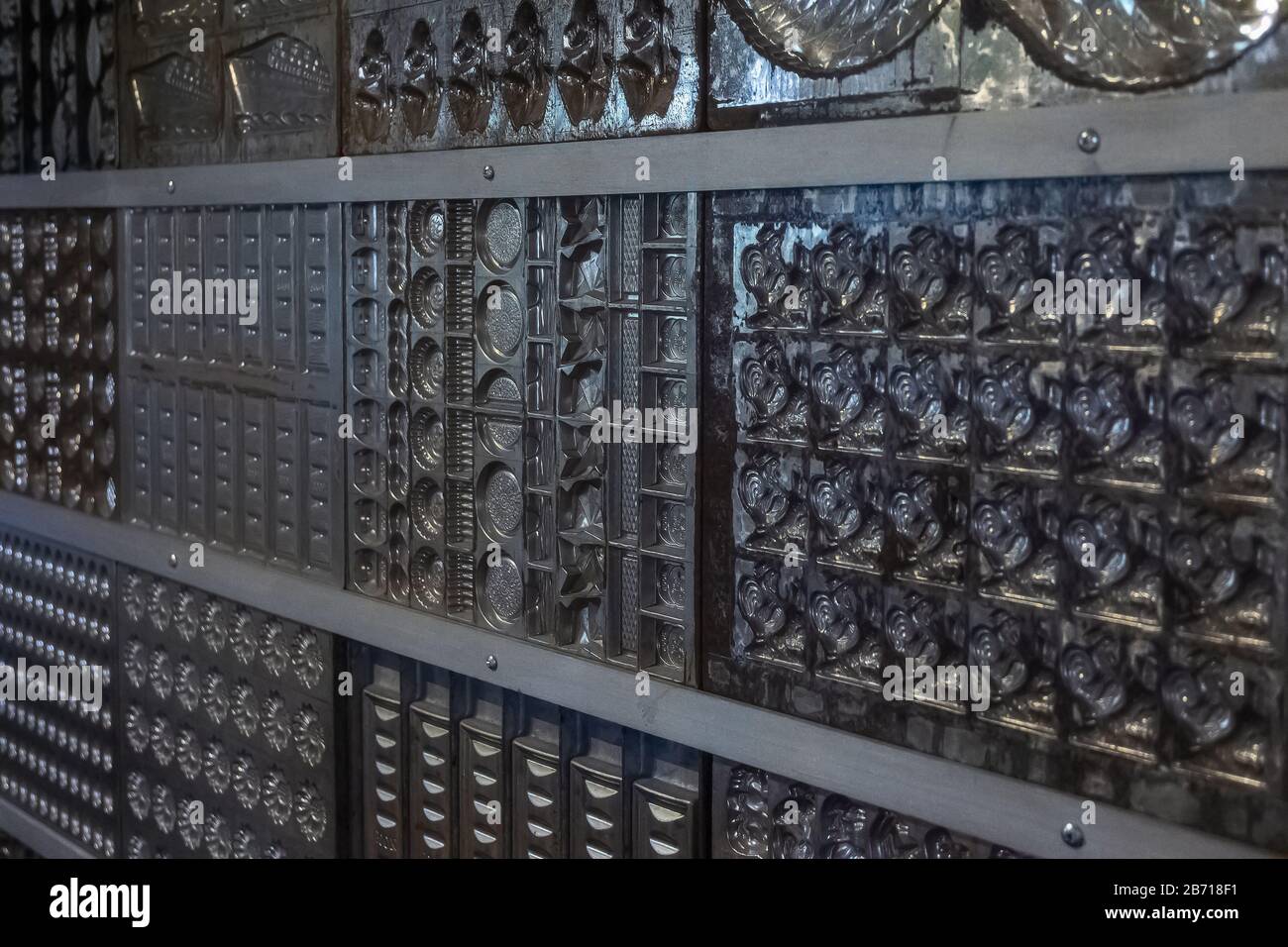 Formen zur Herstellung von Schokoladenbonbons und Bonbons in unterschiedlicher Form, die als Hintergrund angeordnet sind Stockfoto