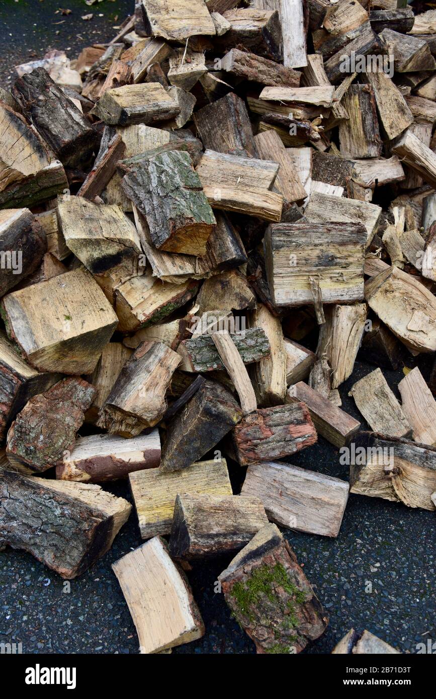 Portraitbild eines Haufens gespaltener gewürzter Hartholzstämme, die vor kurzem zur Verwendung als Brandholz in einem Holzofen geliefert wurden. Stockfoto