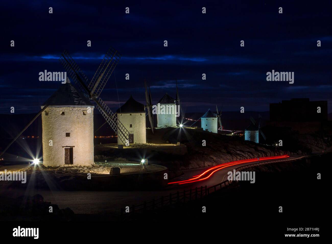 Windmühlen und Schloss von La Mancha. Schöner Blick auf die Nacht mit Lichtwegen.Castilla La Mancha. Spanien Stockfoto