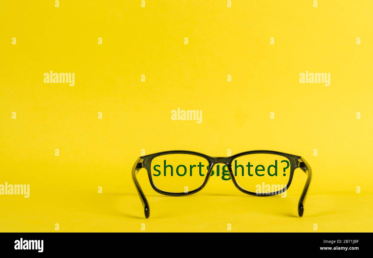 Ein Konzeptbild über die mit Brille und verschwommenen Buchstaben dargestellte Nahsichtigkeit Stockfoto