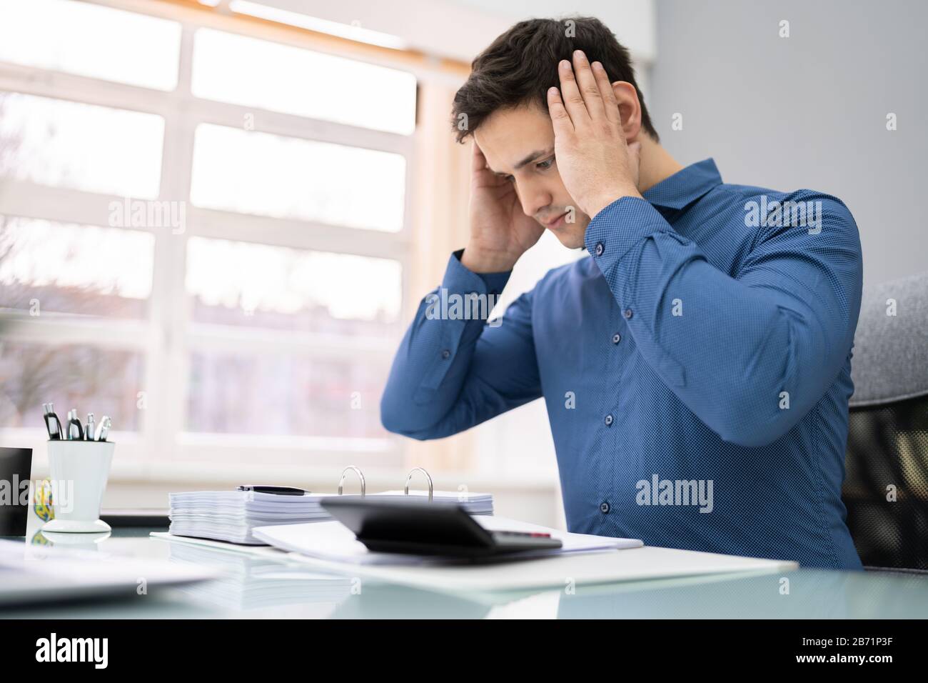 Junge Unternehmer, Die Die Steuer Am Schreibtisch Im Büro Berechnen Stockfoto