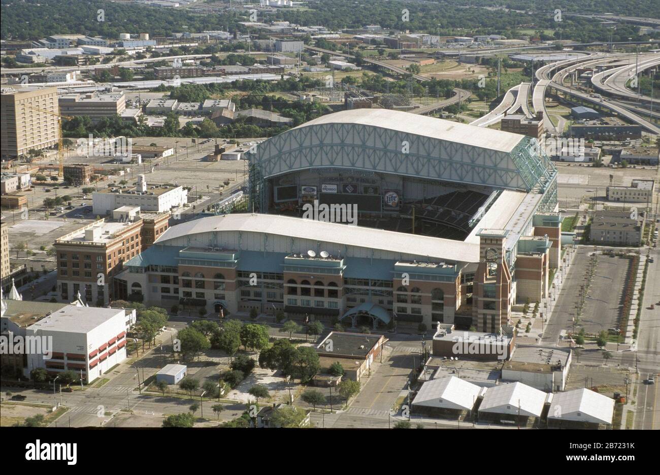 Houston, Texas, August 2001: Luftaufnahmen der Skyline der Innenstadt mit dem Heimstadion des Baseballteams Houston Astros, dem Minute Maid Park (ehemals Enron Field), mit auslackbar geöffnetem Dach im Vordergrund. ©Bob Daemmrich Stockfoto