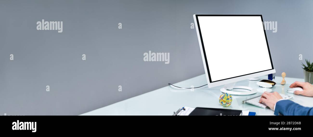 Nahaufnahme Eines Geschäftsmannes, Der Einen Computer Mit Leerem Bildschirm Am Arbeitsplatz verwendet Stockfoto