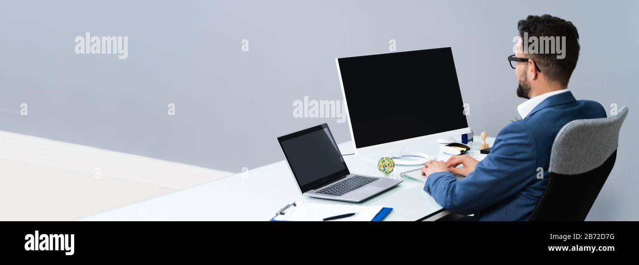 Nahaufnahme Eines Geschäftsmannes, Der Einen Computer Mit Leerem Bildschirm Am Arbeitsplatz verwendet Stockfoto