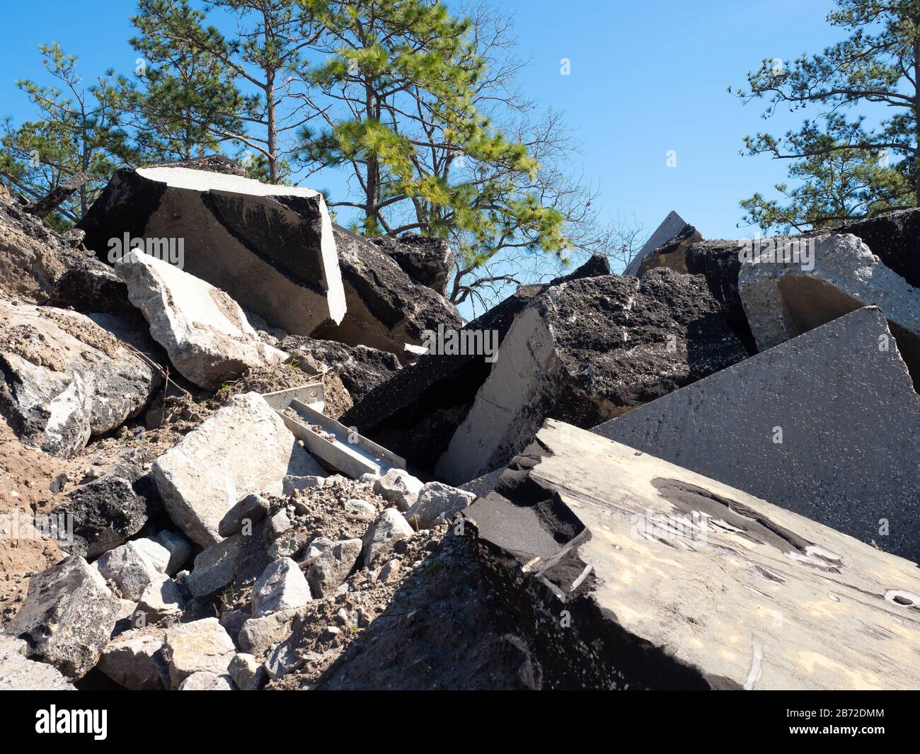 Berg aus Asphalt, Betonroden und Parkplatz Trümmer an der Straße Abriss Ort, Pine Bäume im Hintergrund mittelweite Sicht Stockfoto