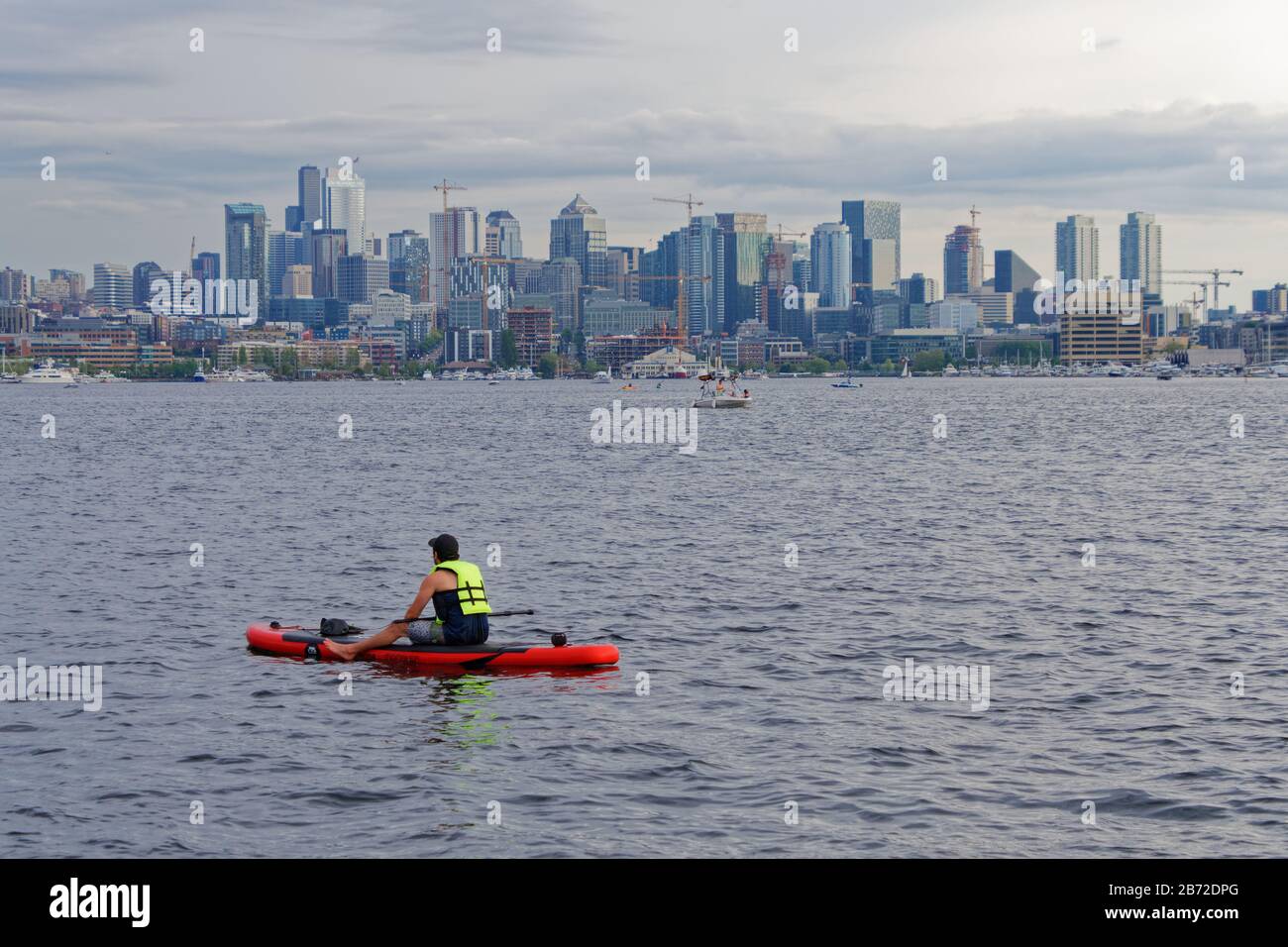 MAI 2018 in SEATTLE, WA: Ein unidentifizierter Mann auf einem Paddle-Brett sitzt auf dem Wasser von Lake Union und blickt nach Süden in Richtung Seattles schöne Skyline. Stockfoto