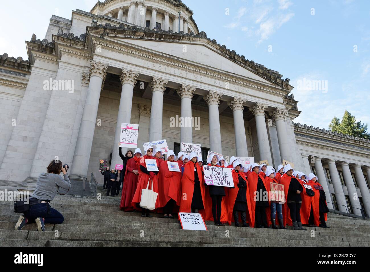OLYMPIA, WA, 14. OKTOBER 2017: Männer und Frauen, die in Handmaid's Tale Kostümen gekleidet sind, sammeln sich auf den Stufen der Washingtoner Staatskapitol, um Trump gegenüber zu protestieren Stockfoto