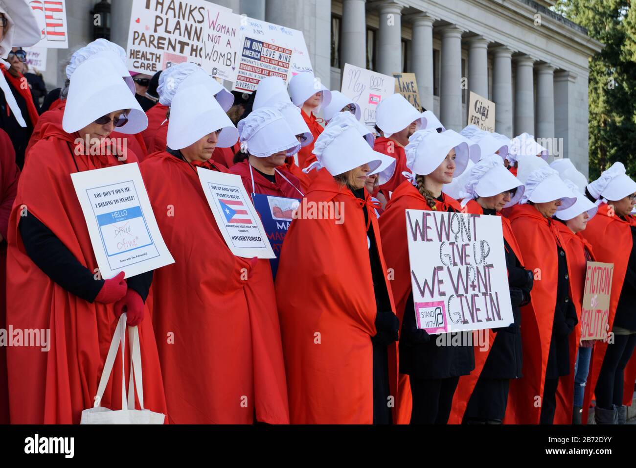 OLYMPIA, WA, 14. OKTOBER 2017: Männer und Frauen, die in Handmaid's Tale Kostümen gekleidet sind, sammeln sich auf den Stufen der Washingtoner Staatskapitol, um Trump gegenüber zu protestieren Stockfoto