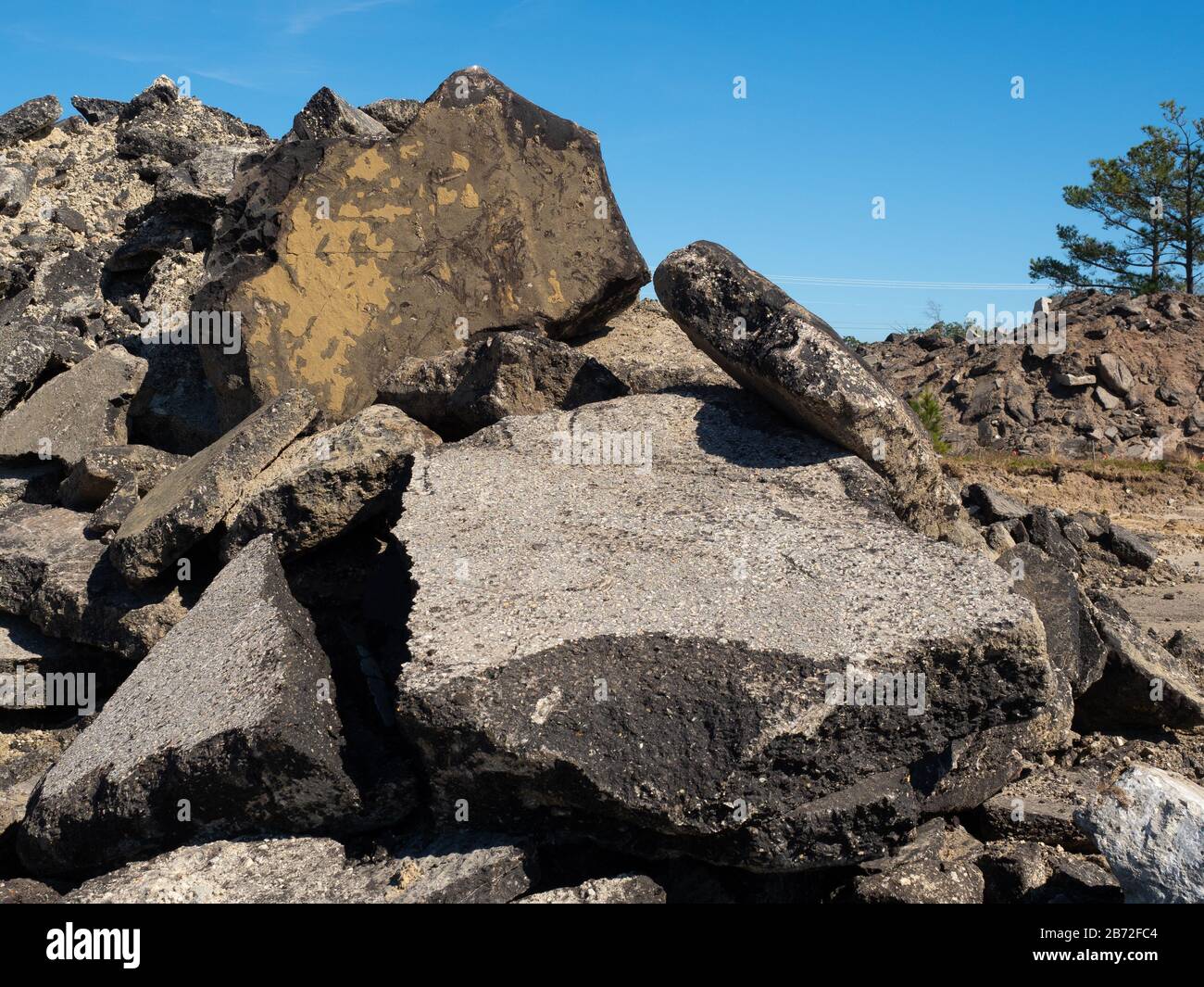 Zwei Berge Straßenschutt, Beton- und Asphaltpflastertrümmer, bauschähnliche Abschnitte von Straßenpflaster und Straßenbelag im Vordergrund Stockfoto