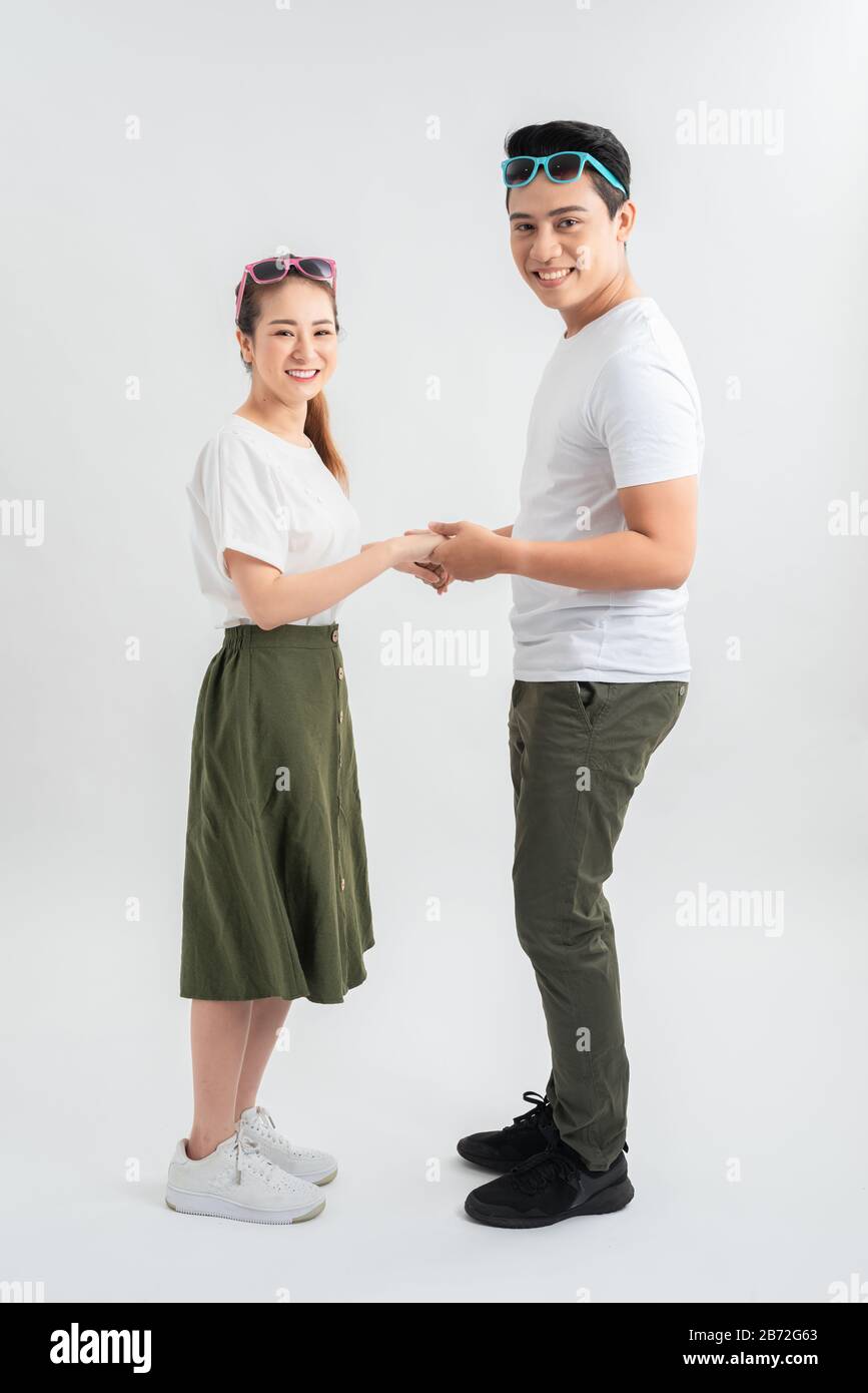 Lange Aufnahme von asiatischem Paar isoliert auf Weiß. Mann in legerer Kleidung mit Freundin abkühlen Stockfoto