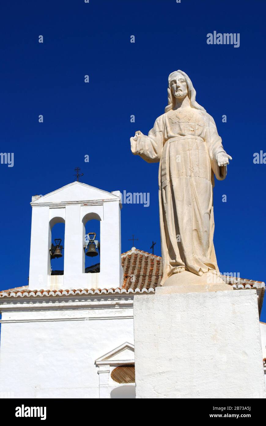 Blick auf Die Einsiedelei Unserer Lieben Frau der Heilmittel mit einer Statue im Vordergrund, Velez Malaga, Costa del Sol, Provinz Málaga, Andalucia, Spanien. Stockfoto