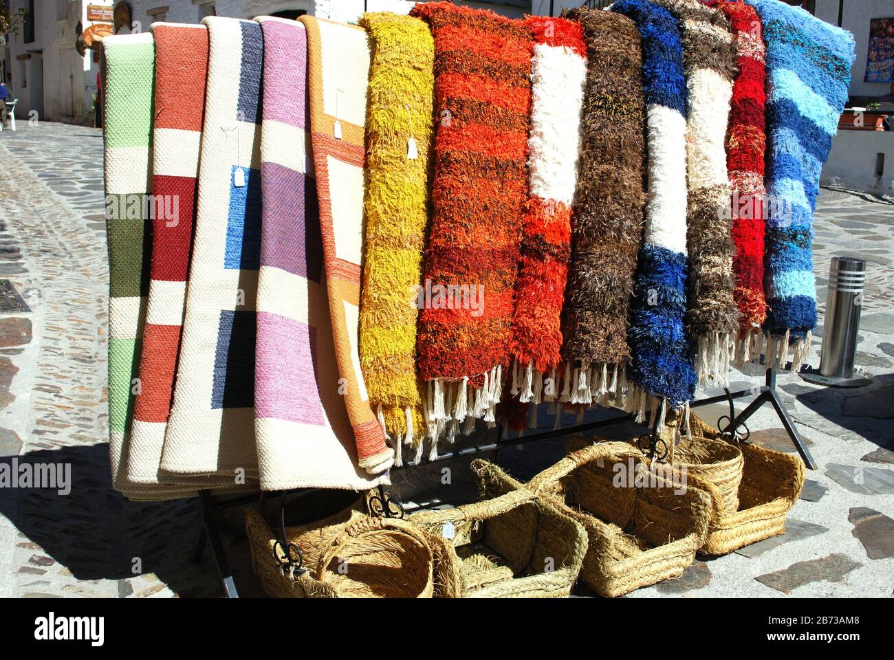 Vor Ort hergestellte Teppiche zum Verkauf vor einem Dorf Handwerk und Souvenirladen, Pampaneira, Spanien, Europa. Stockfoto