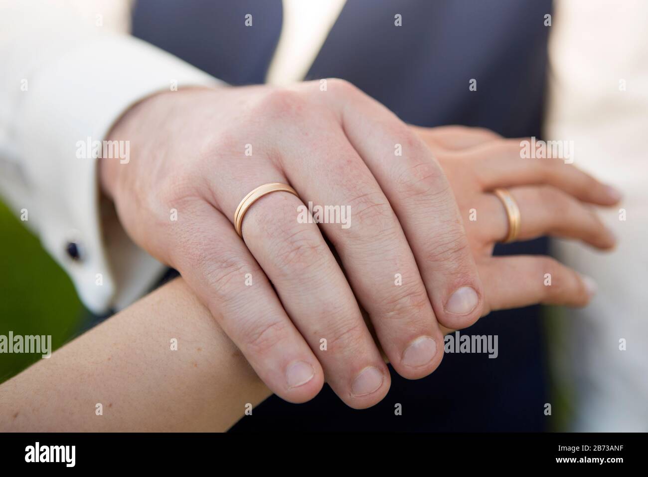 Hände von brautpaar mit Hochzeitsringen im Freien Stockfoto